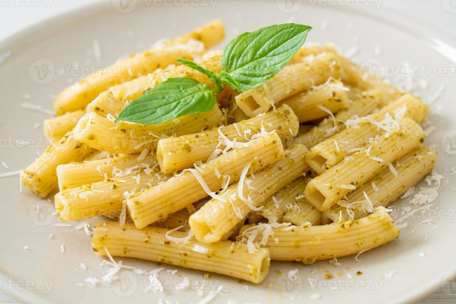 pesto rigatoni pasta met Parmezaanse kaas - Italiaans eten en vegetarische eetstijl foto