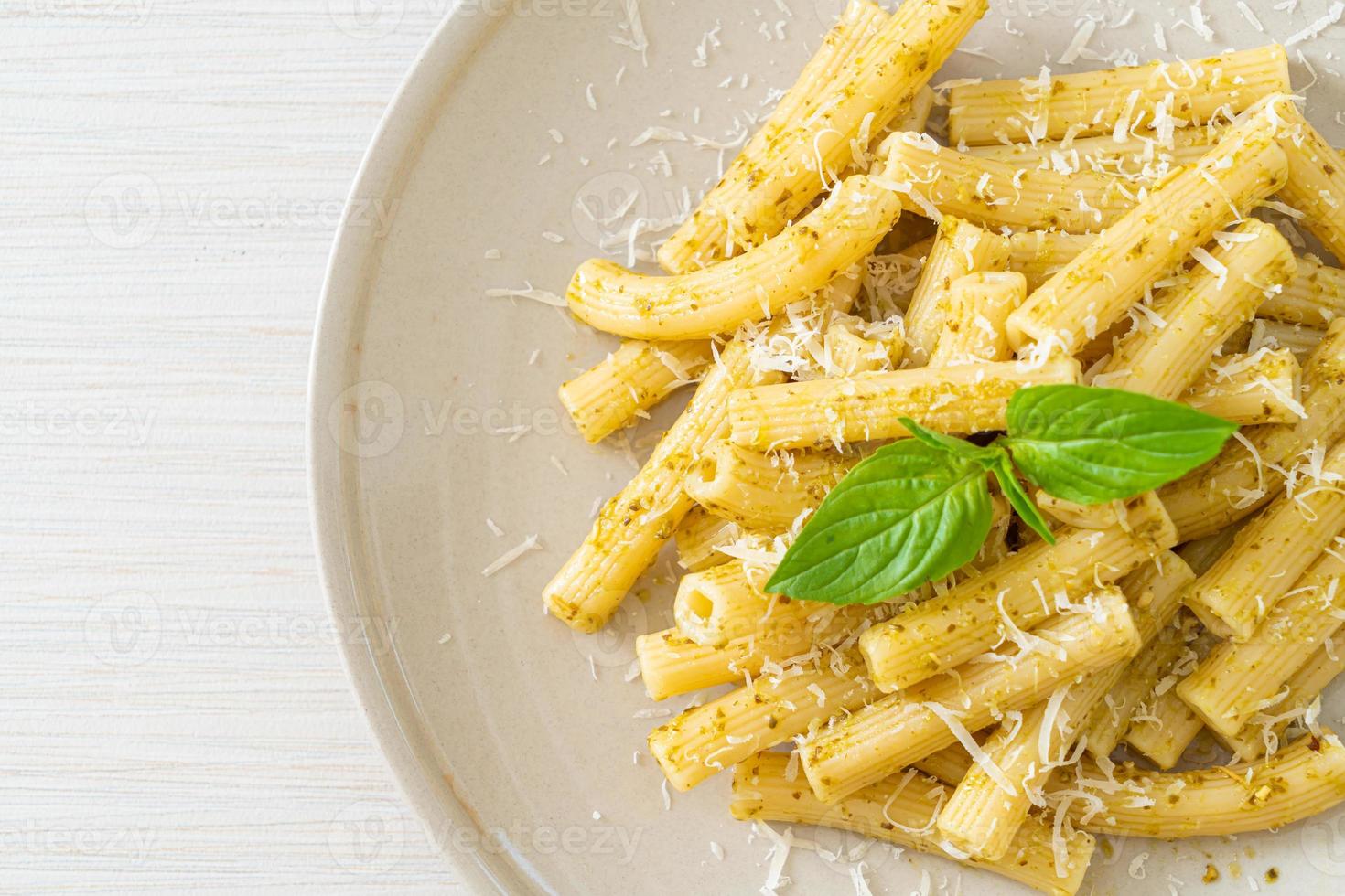 pesto rigatoni pasta met Parmezaanse kaas - Italiaans eten en vegetarische eetstijl foto