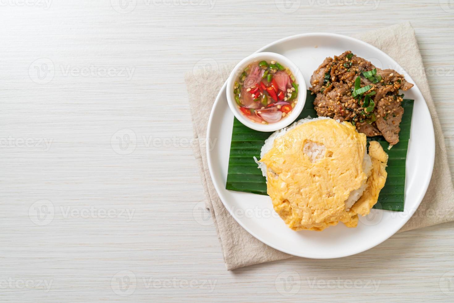 ei op gegarneerde rijst met gegrild varkensvlees en pikante saus - Aziatisch eten foto