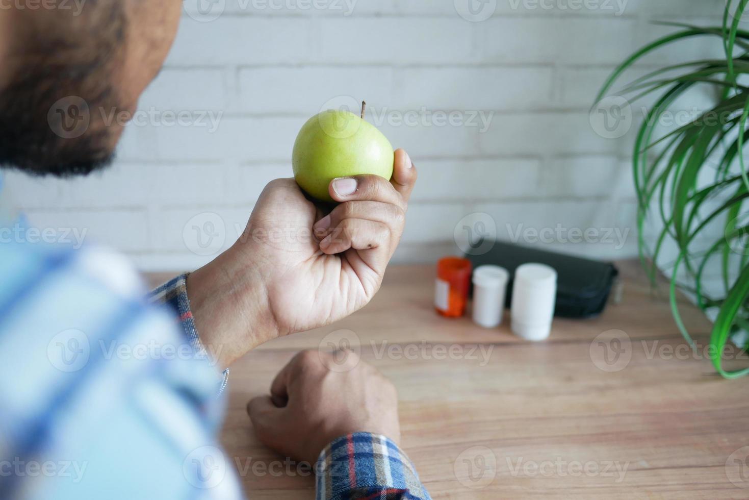 achteraanzicht van de hand van de jonge man met groene appel foto