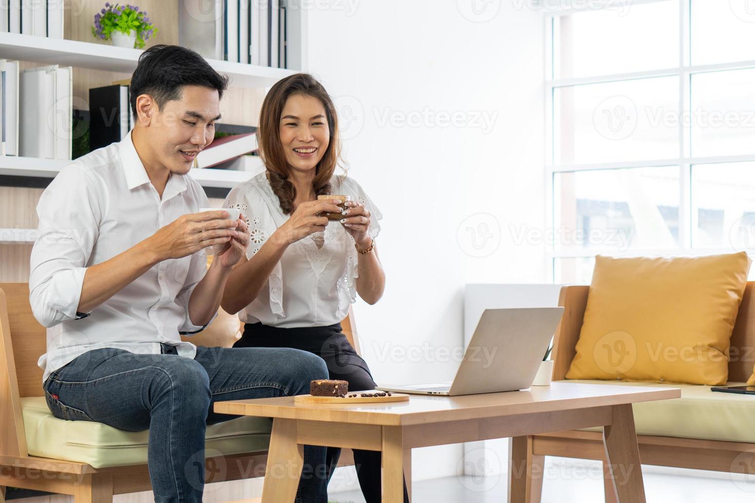 Aziatische vrouw en man zitten in het café en genieten van het drinken van espresso foto