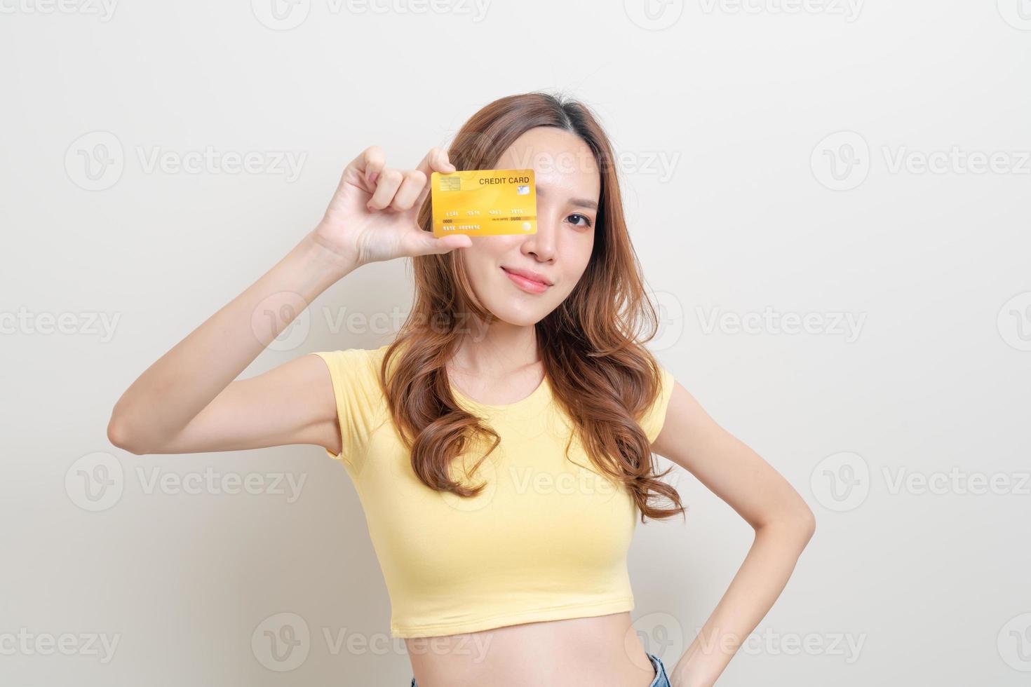 portret mooie aziatische vrouw met creditcard op witte achtergrond foto