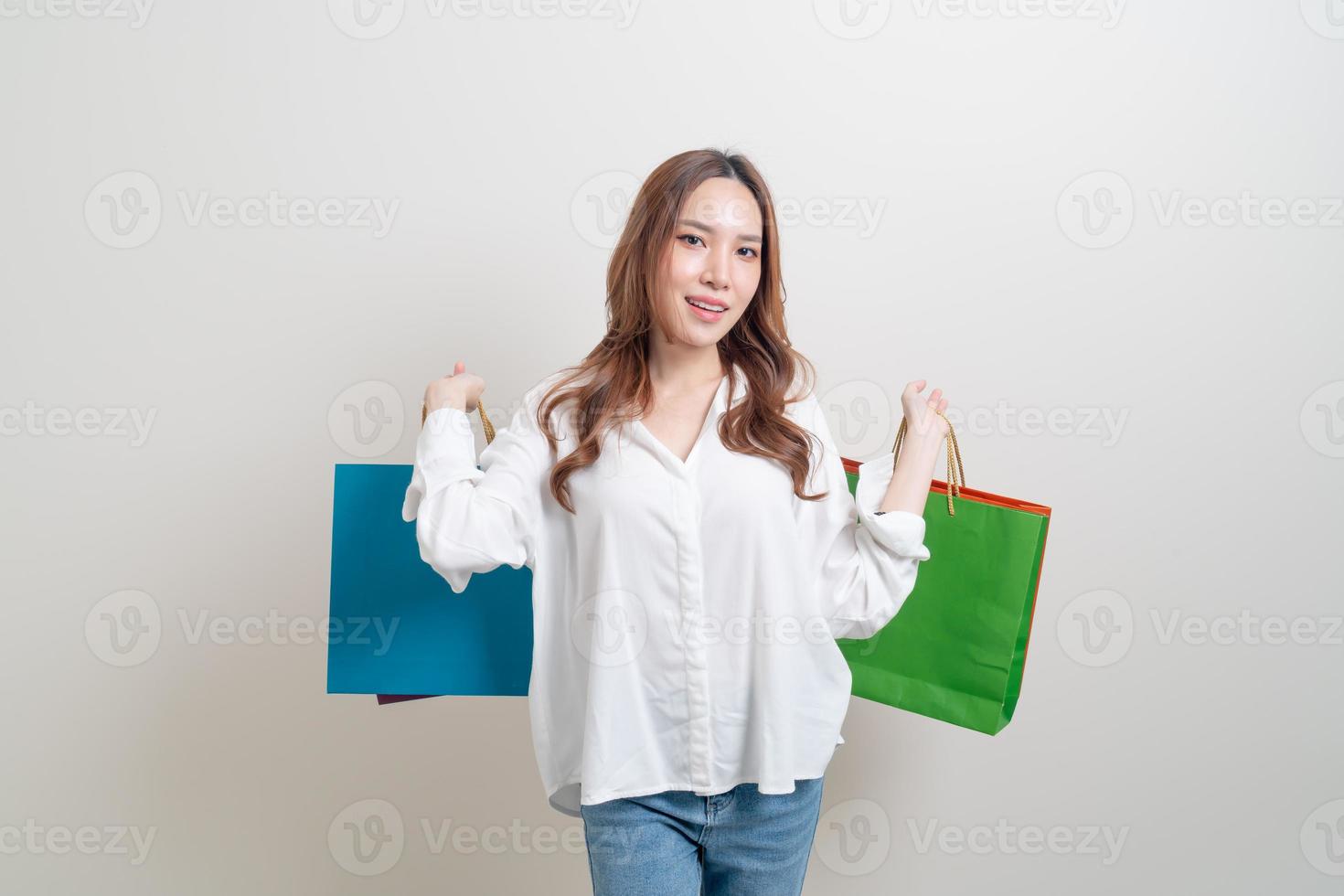 portret mooie aziatische vrouw met boodschappentas op witte achtergrond foto