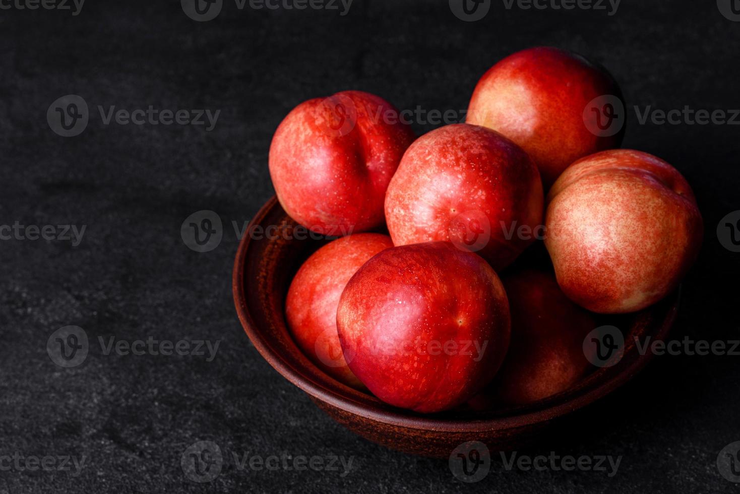 heerlijke zoete perziken of nectarines in een bruine kom foto