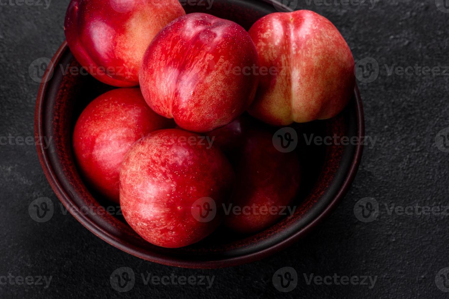 heerlijke zoete perziken of nectarines in een bruine kom foto