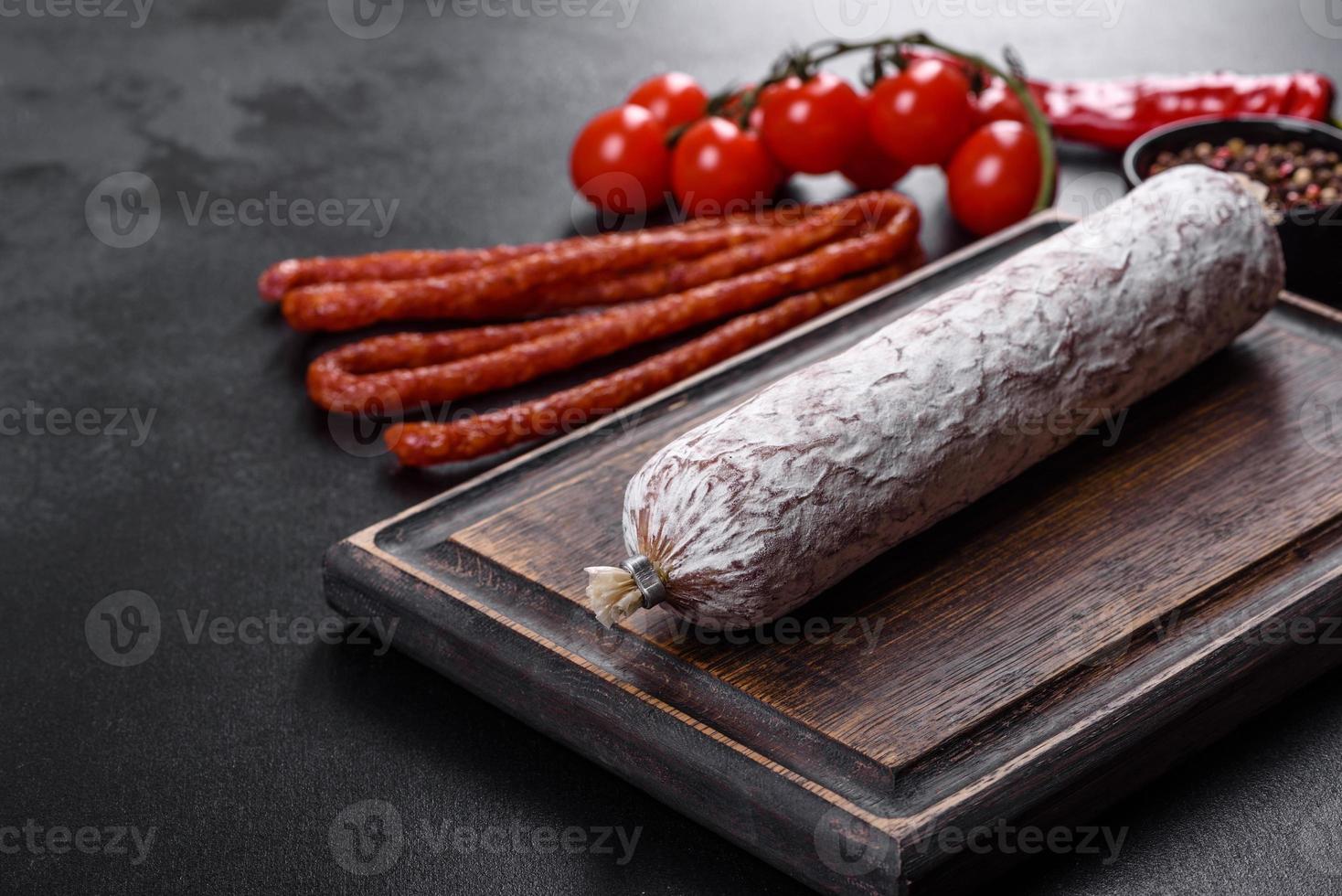 Spaanse gedroogde worstsalami op een donkere betonnen ondergrond foto