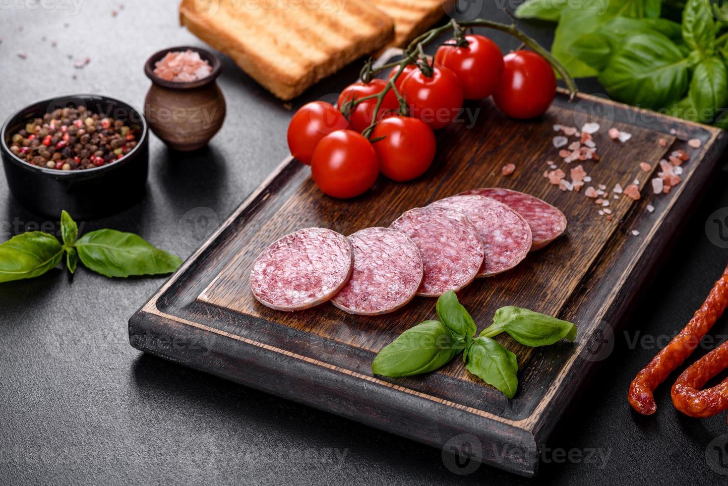 Spaanse gedroogde worstsalami op een donkere betonnen ondergrond foto