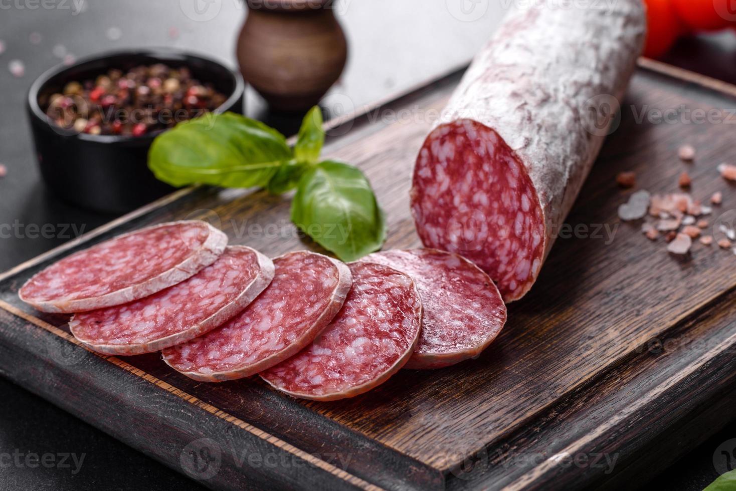 Spaanse gedroogde worstsalami op een donkere betonnen ondergrond foto