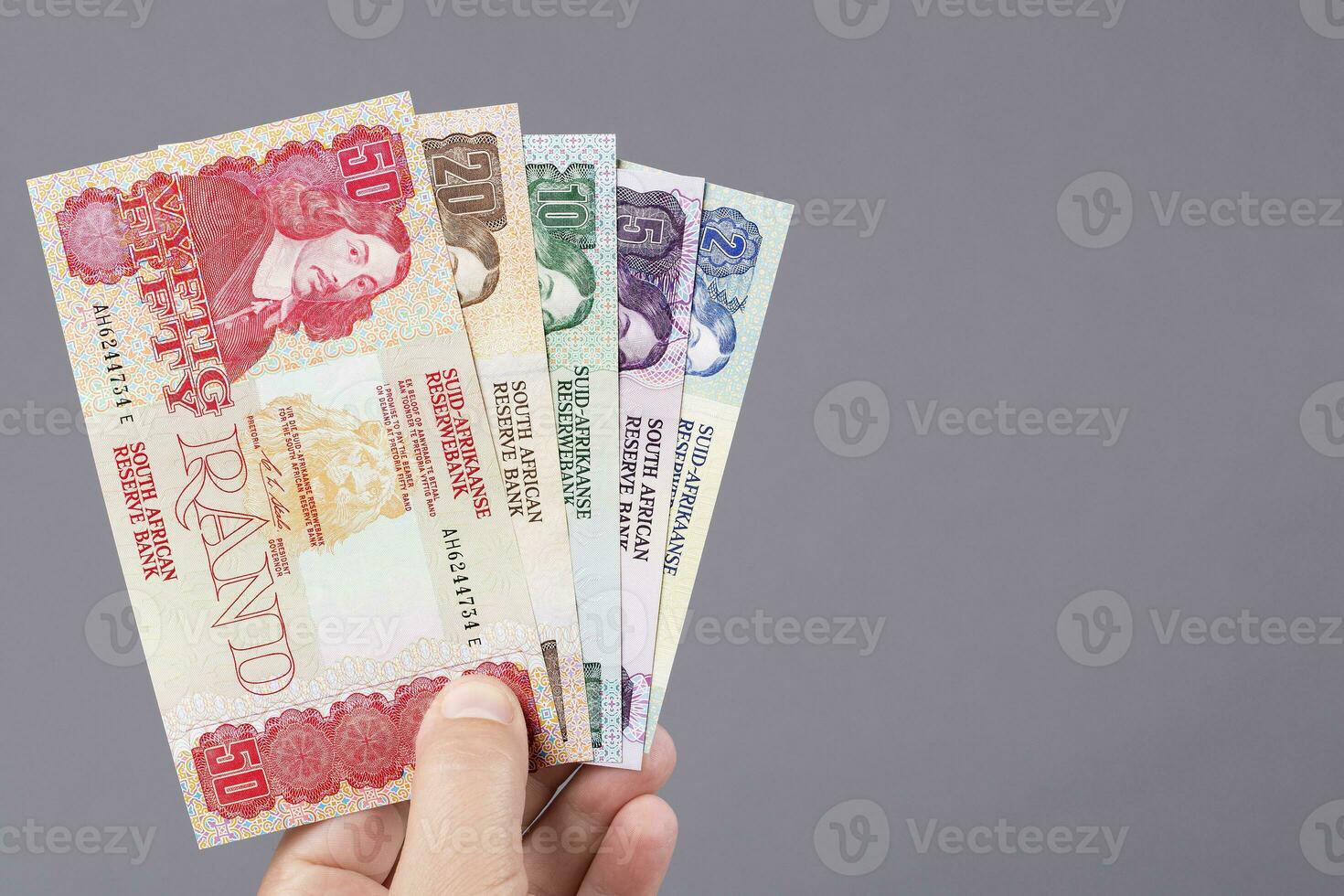 oud zuiden Afrikaanse geld in de hand- Aan een grijs achtergrond foto