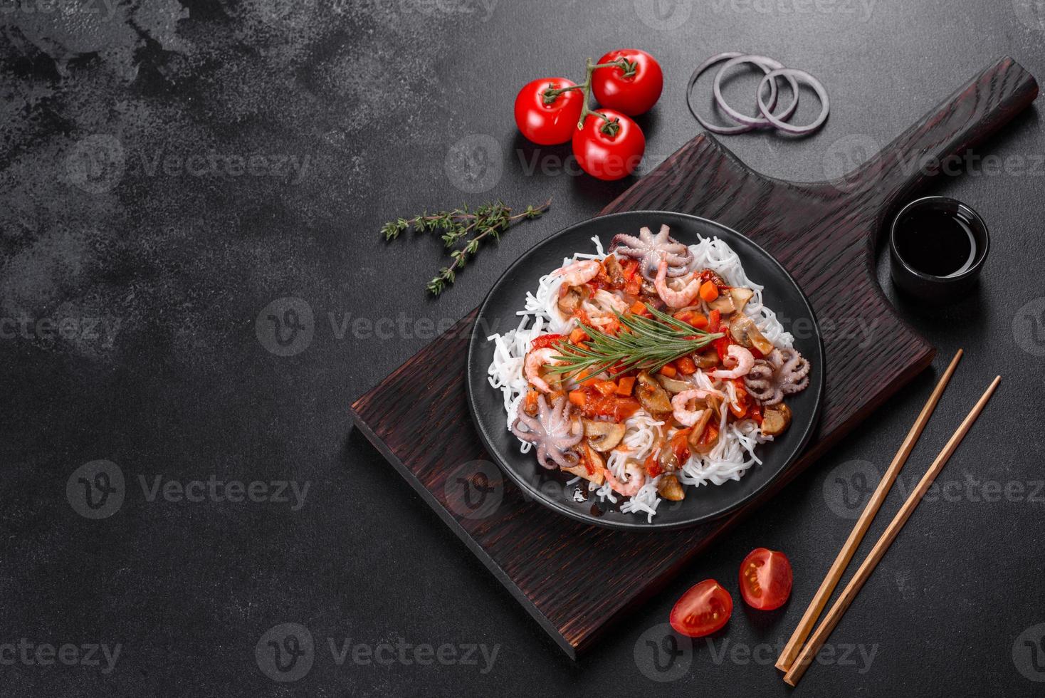 smakelijke rijstnoedels met tomaat, rode paprika, champignons en zeevruchten foto