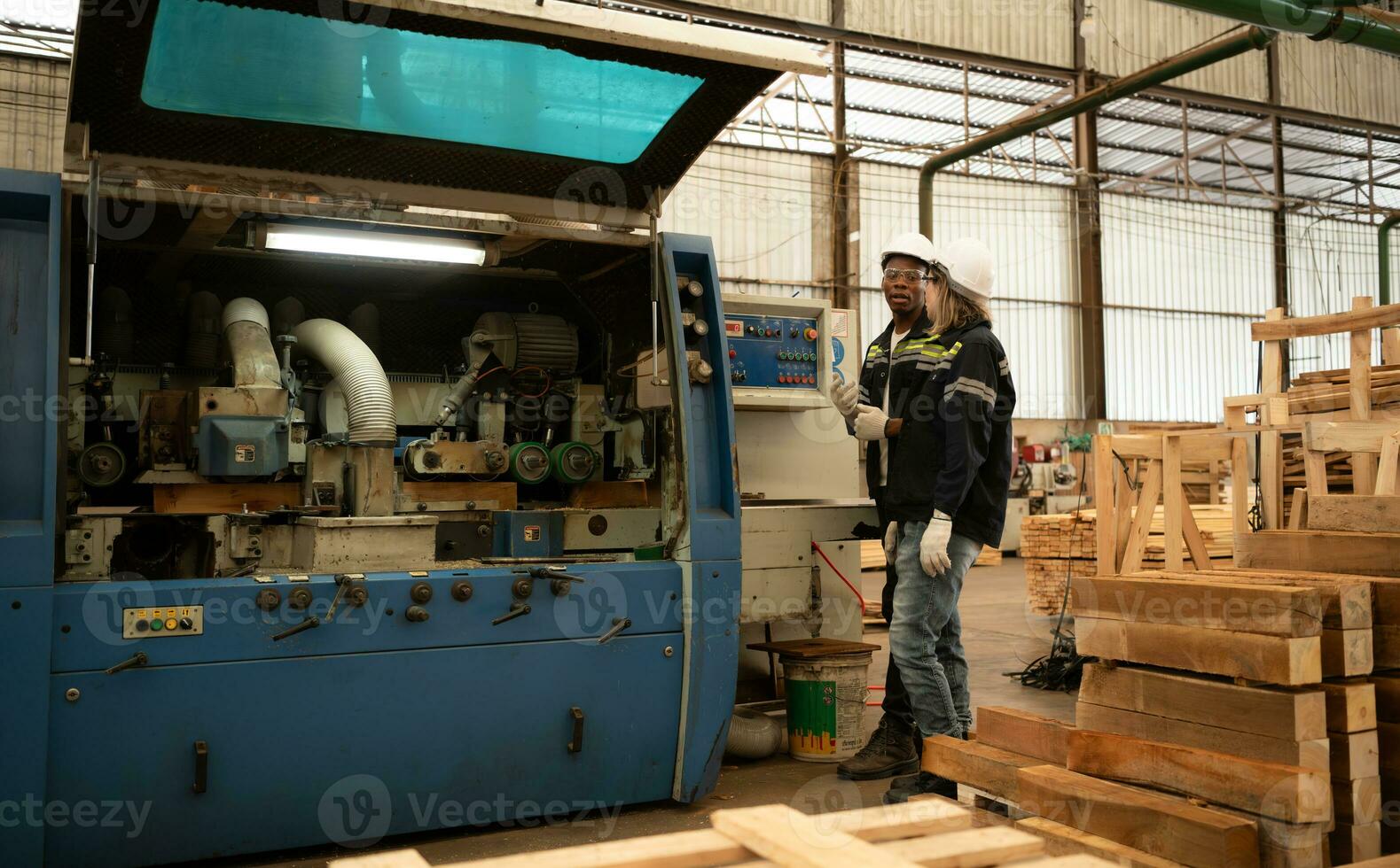 beide arbeiders werk in een houtbewerking fabriek, werken met hout zagen en snijdend machines naar produceren houten lakens voor maken pallets foto