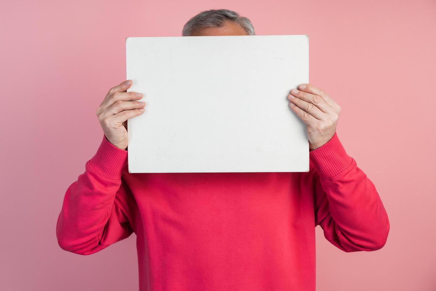 man bedekt zijn gezicht met een wit vel papier foto