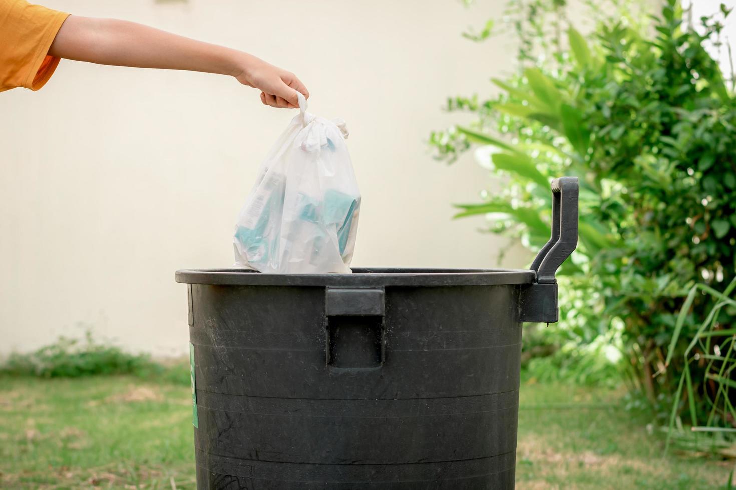 Dubbelzinnigheid Maakte zich klaar Wennen aan gooi afval in plastic zakken in de prullenbak in de tuin. 3164467 Stockfoto