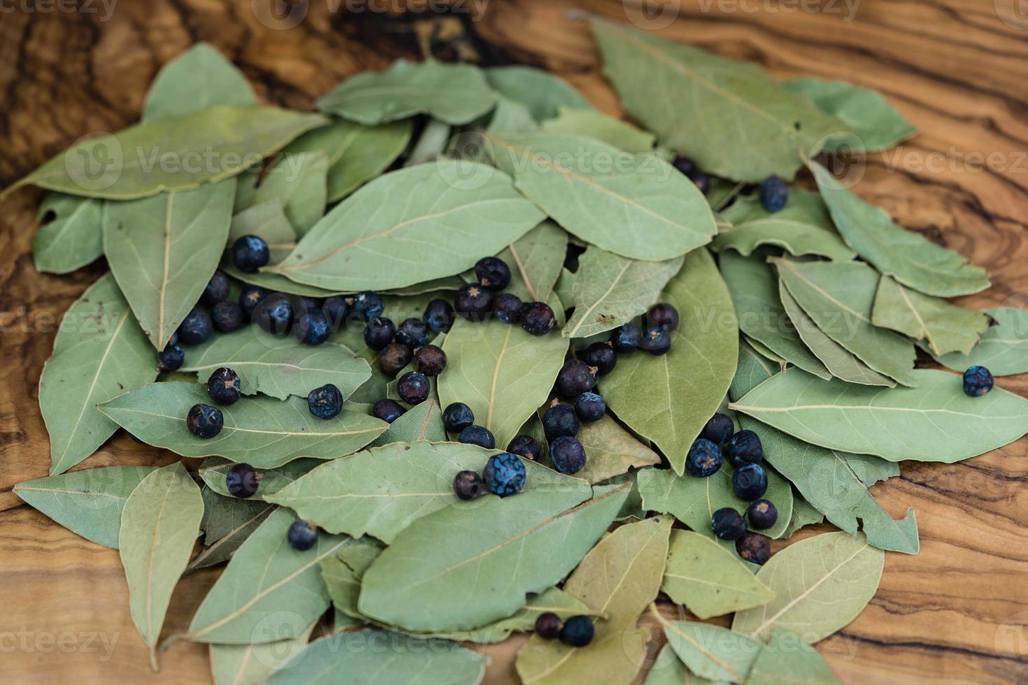 laurierblaadjes en jeneverbessen op olijfhout foto