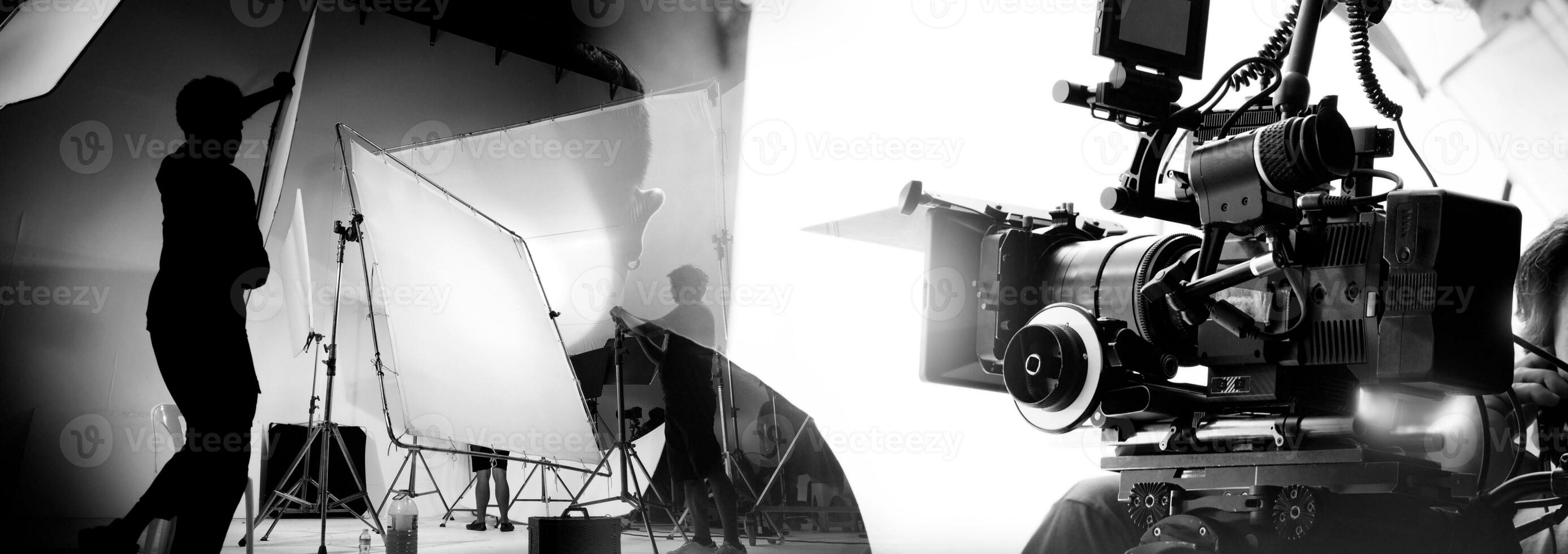 silhouet van video productie achter de scènes of b rollen of maken van TV reclame film dat film bemanning team licht man en cameraman werken samen met regisseur in groot studio met pro uitrustingen foto