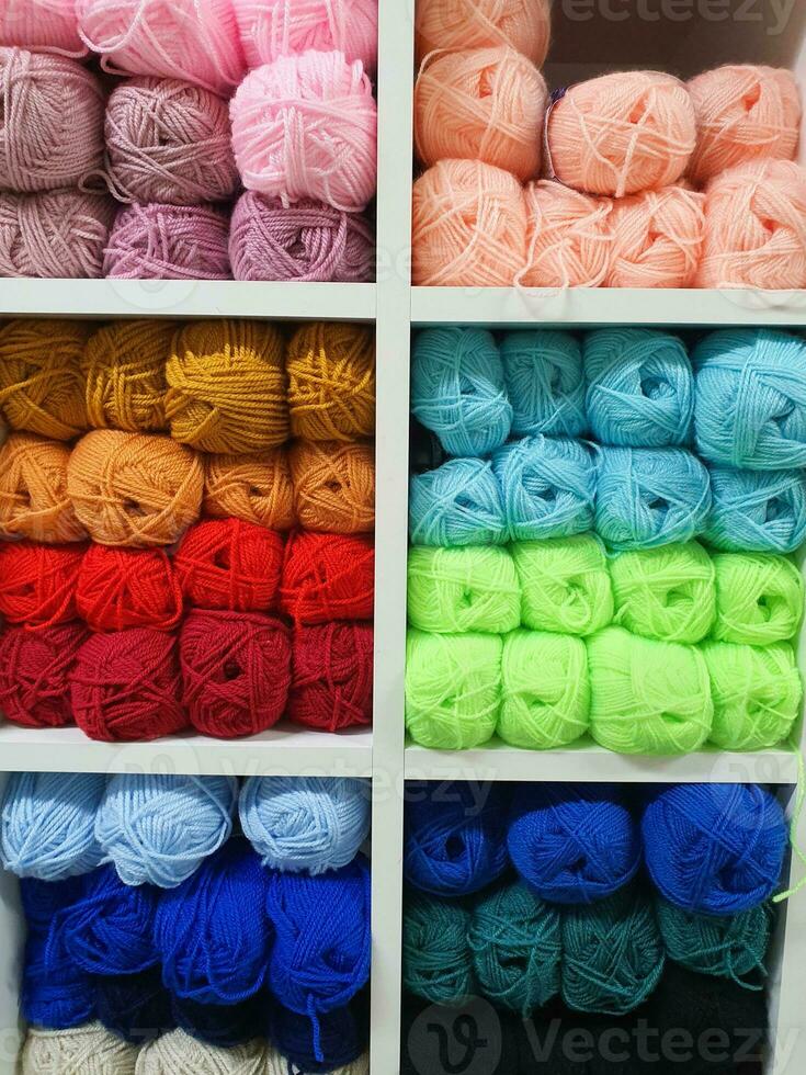 kleurrijk garens van wol voor breiwerk Aan schappen in de fournituren winkel. breiwerk handgemaakt concept foto