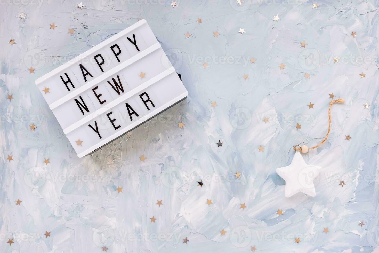 woorden gelukkig nieuw jaar met zilver sterren confetti decoratie Aan blauw achtergrond. nieuw jaar voorbereiding en viering concept. vlak leggen, top visie, kopiëren ruimte foto