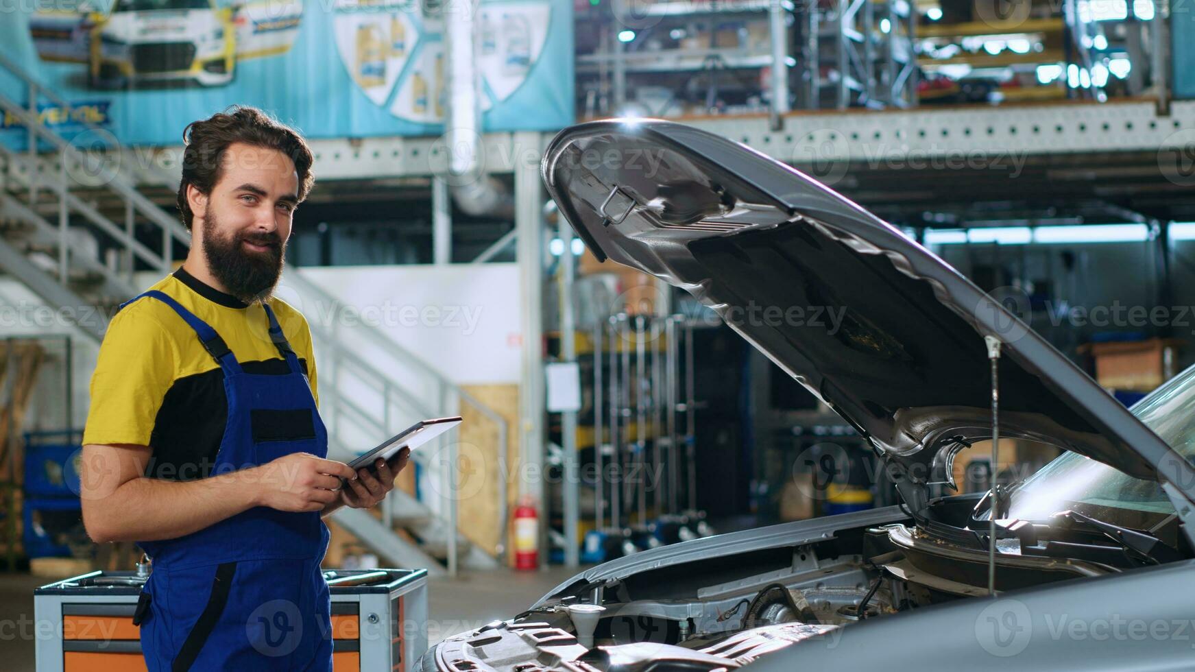 portret van glimlachen monteur in auto reparatie winkel aan het doen auto jaar- controle, op zoek voor schade. gelukkig klusjesman Bij werk controle naar zien als voertuig onderdelen zijn naar behoren functioneren foto