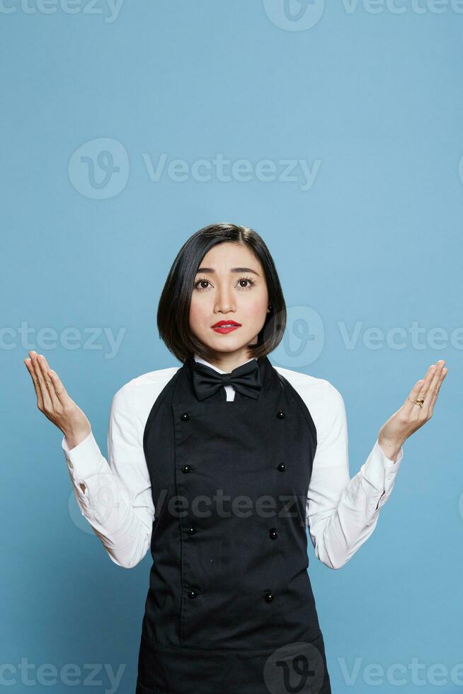 restaurant jong Aziatisch vrouw werknemer bidden met Open armen en op zoek omhoog. cafe aantrekkelijk serveerster vervelend professioneel uniform mediteren, beoefenen ontspanning in studio foto