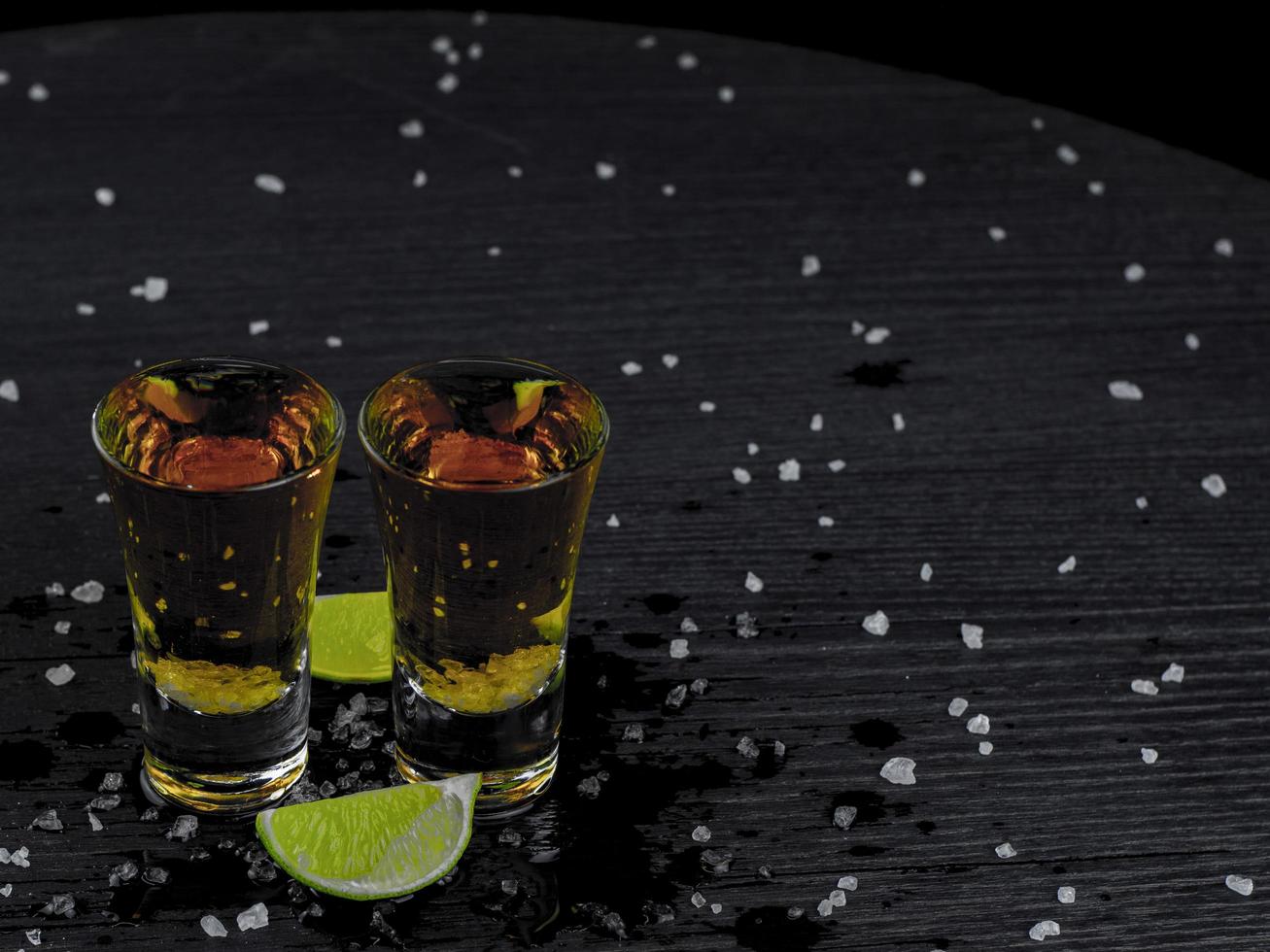 twee shots tequila goud met sappige limoen foto