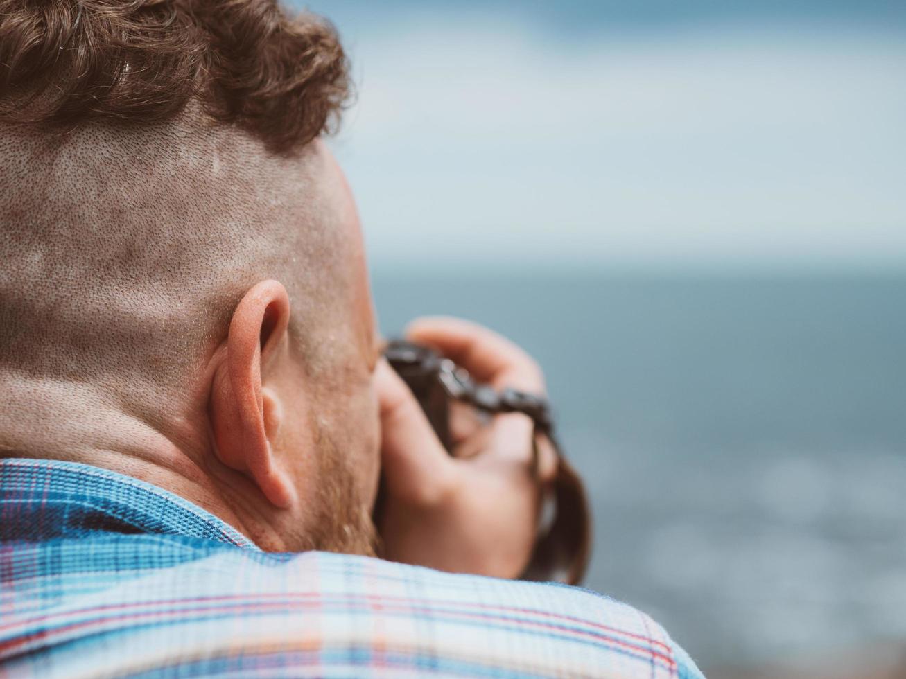 mannelijke fotograaf met camera in de buurt van de zee foto