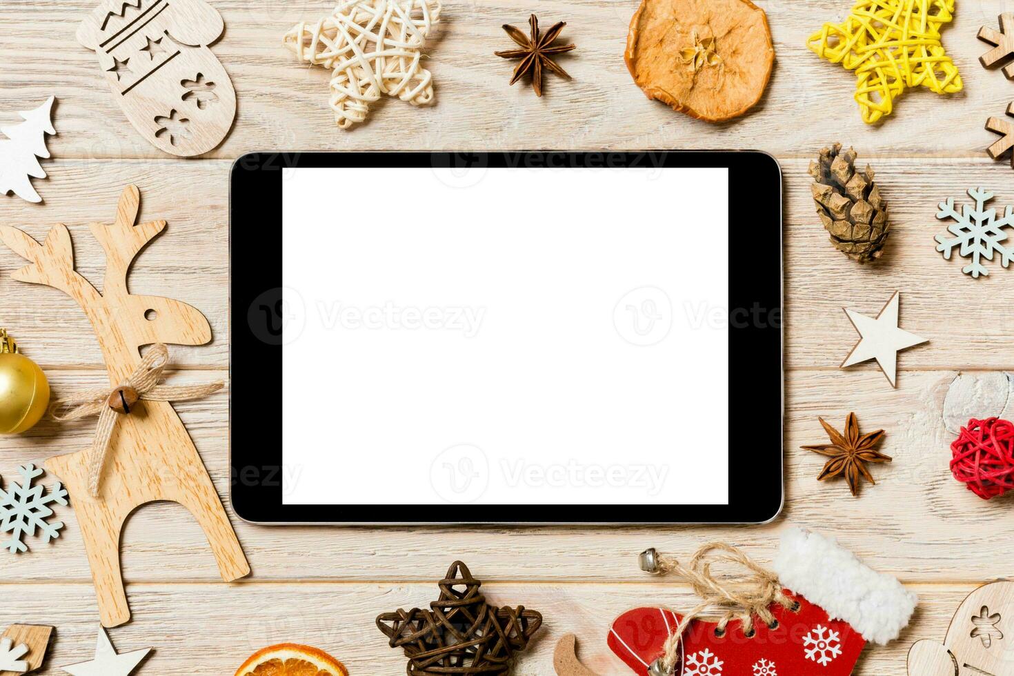 top visie van tablet Aan vakantie houten achtergrond. nieuw jaar decoraties en speelgoed. Kerstmis concept foto