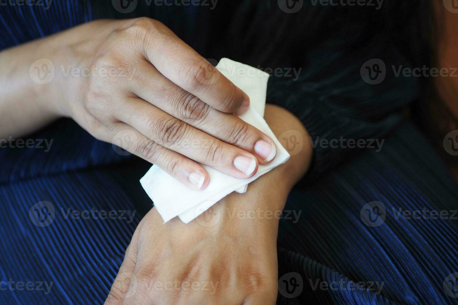 Dames desinfecteren zijn handen met een nat veeg. foto