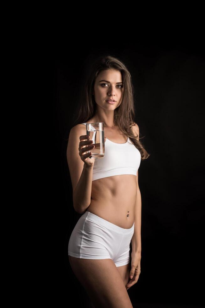 vrouwelijk fitnessmodel met een waterglas foto