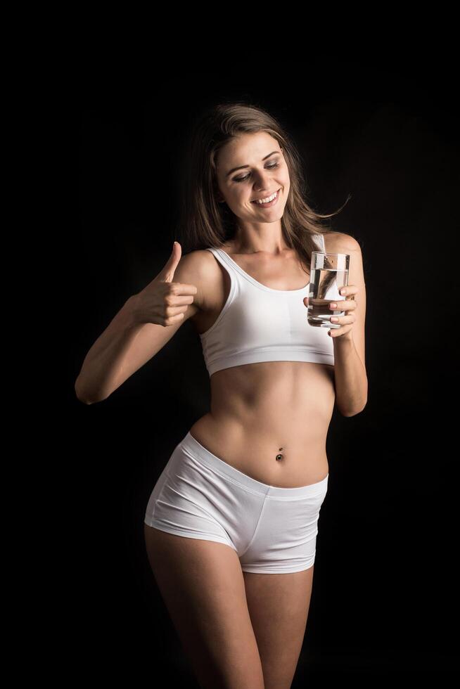 vrouwelijk fitnessmodel met een waterglas foto