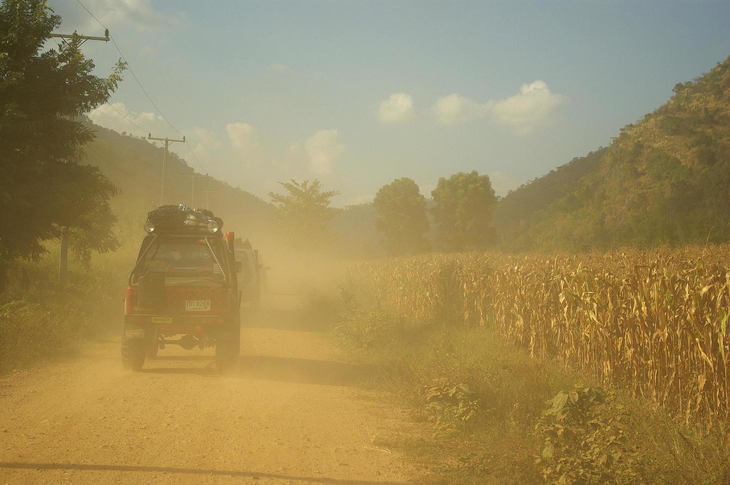 kanchanaburi thailand - 14 mei - niet-geïdentificeerde mannen rijden suzuki sportief en suzuki caribien in het konvooi toercaravans op 14 mei 2006, door de korenvelden langs de onverharde weg, kanchanaburi, thailand. foto