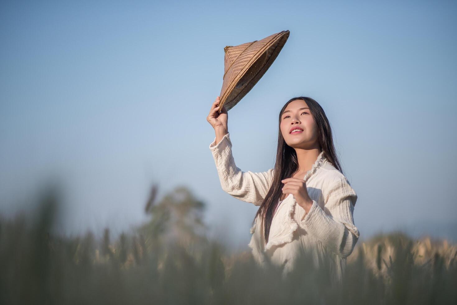 Vietnamese vrouwelijke boer in tarweoogstveld foto