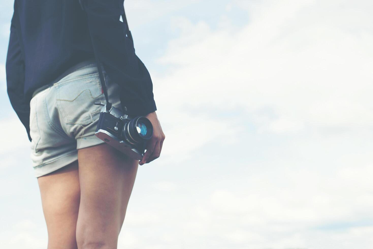 mooie vrouwen fotograaf staande hand met retro camera foto