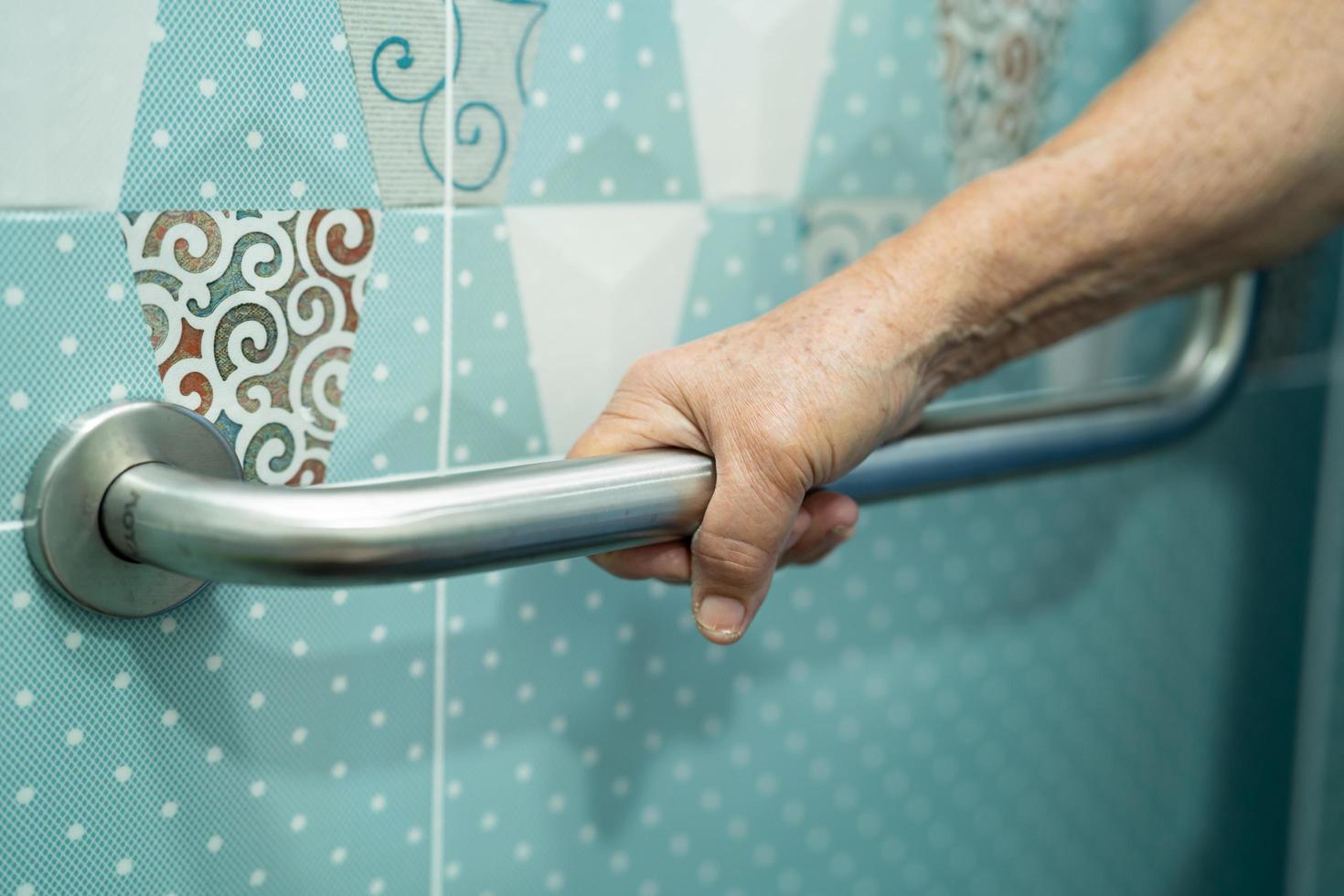 Aziatische senior vrouw patiënt gebruik toilet badkamer handvat beveiliging foto