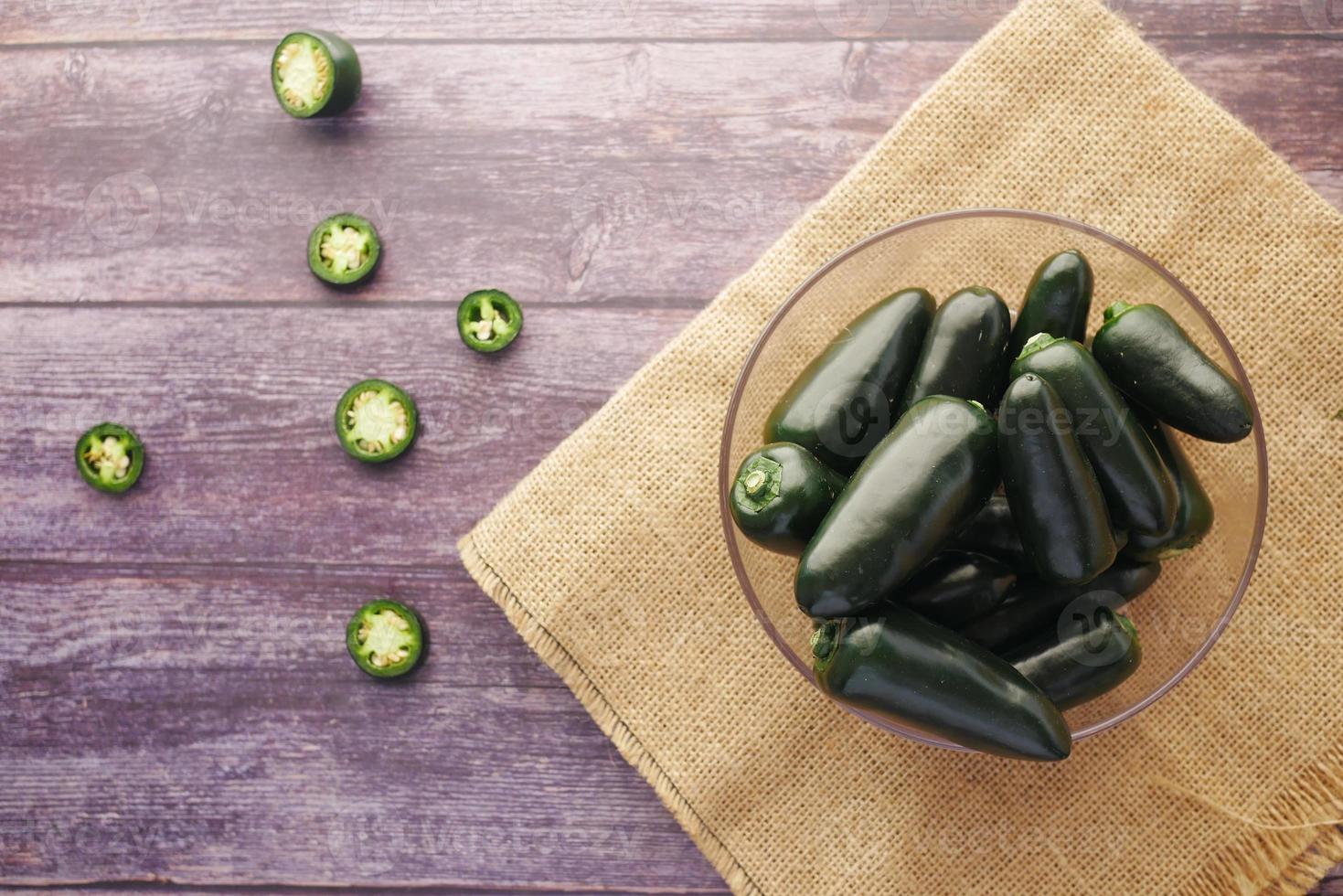 verse jalapenopepers in een kom op tafel, bovenaanzicht foto