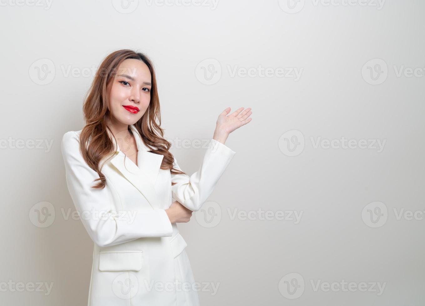 portret mooie Aziatische zakenvrouw met hand presenteren of wijzen op witte achtergrond foto