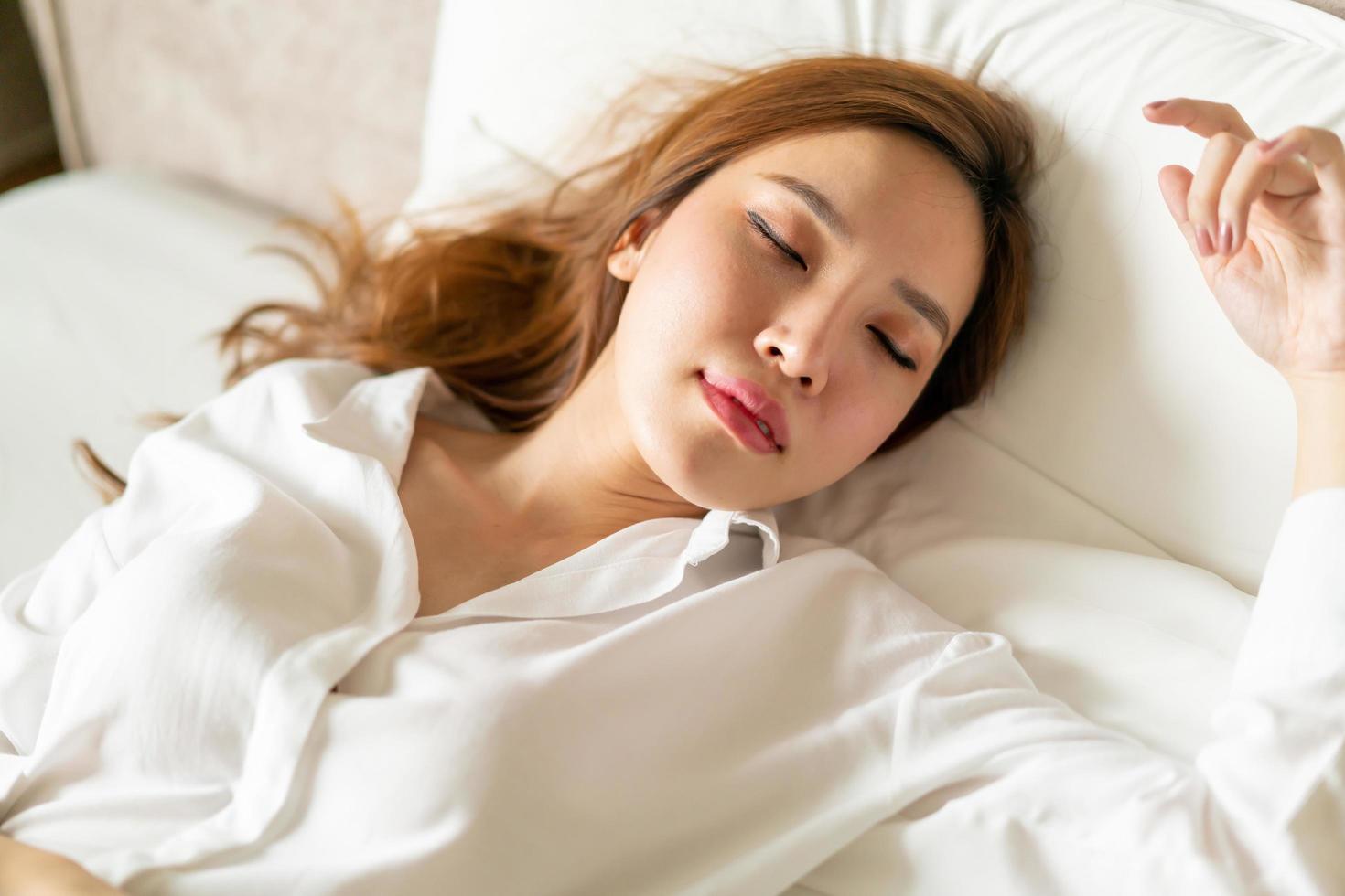 portret mooie aziatische vrouw slapen op bed met wit kussen foto