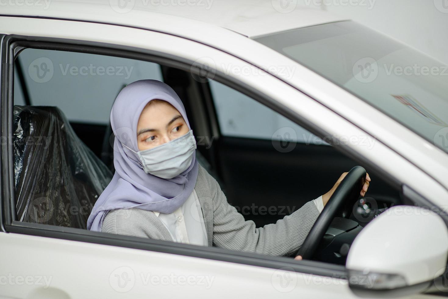 vrouw die beschermingsmasker in auto draagt foto