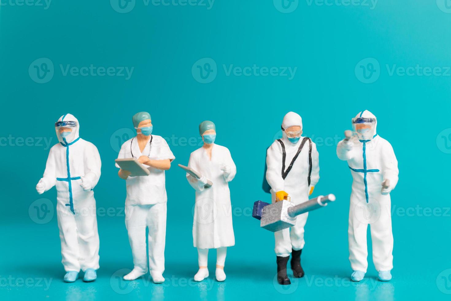 miniatuurteam van artsen, mannen en vrouwen die ziekten en virussen bestrijden foto