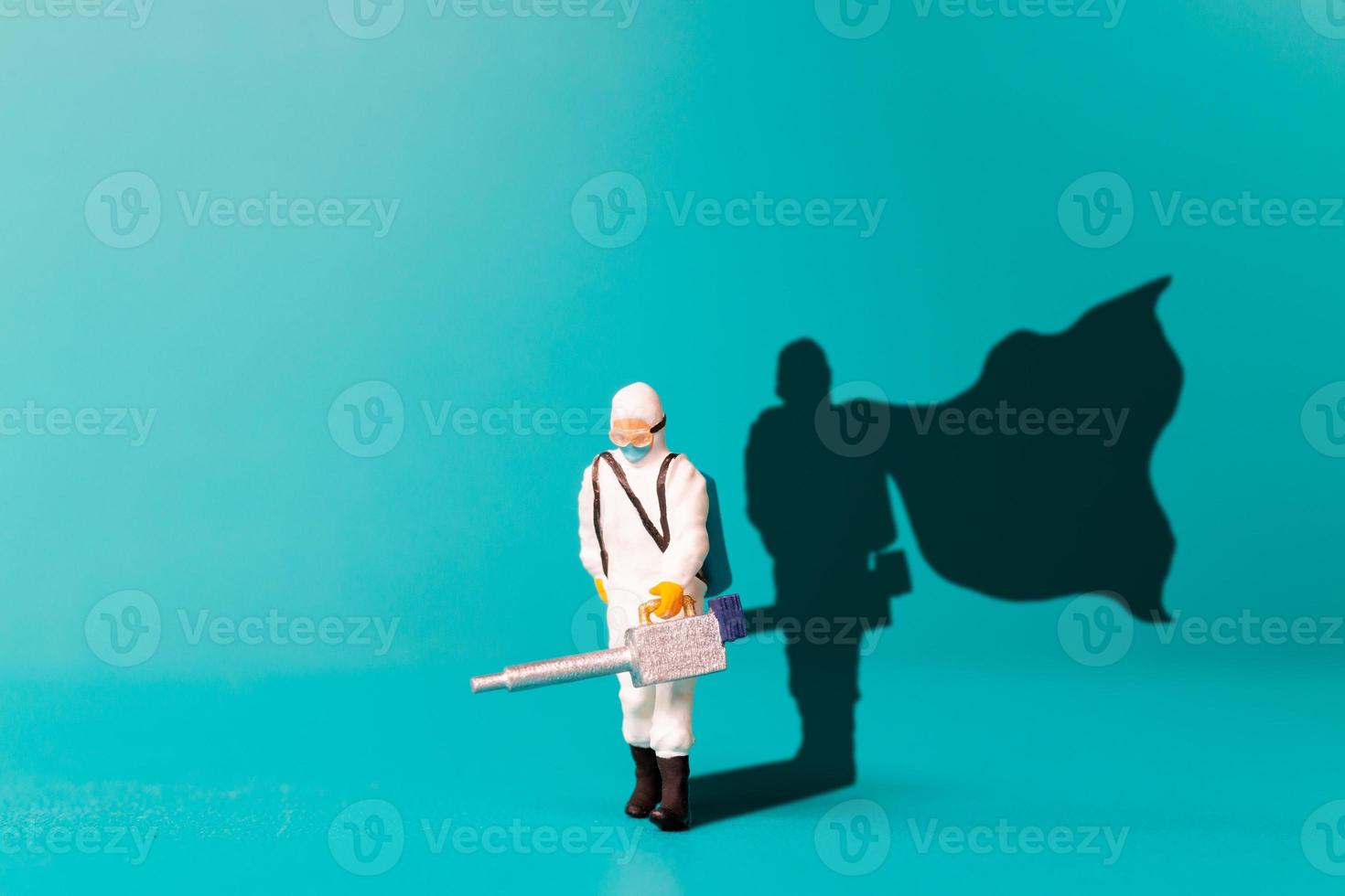 miniatuur mensen dokter met superheld schaduw op de muur. foto
