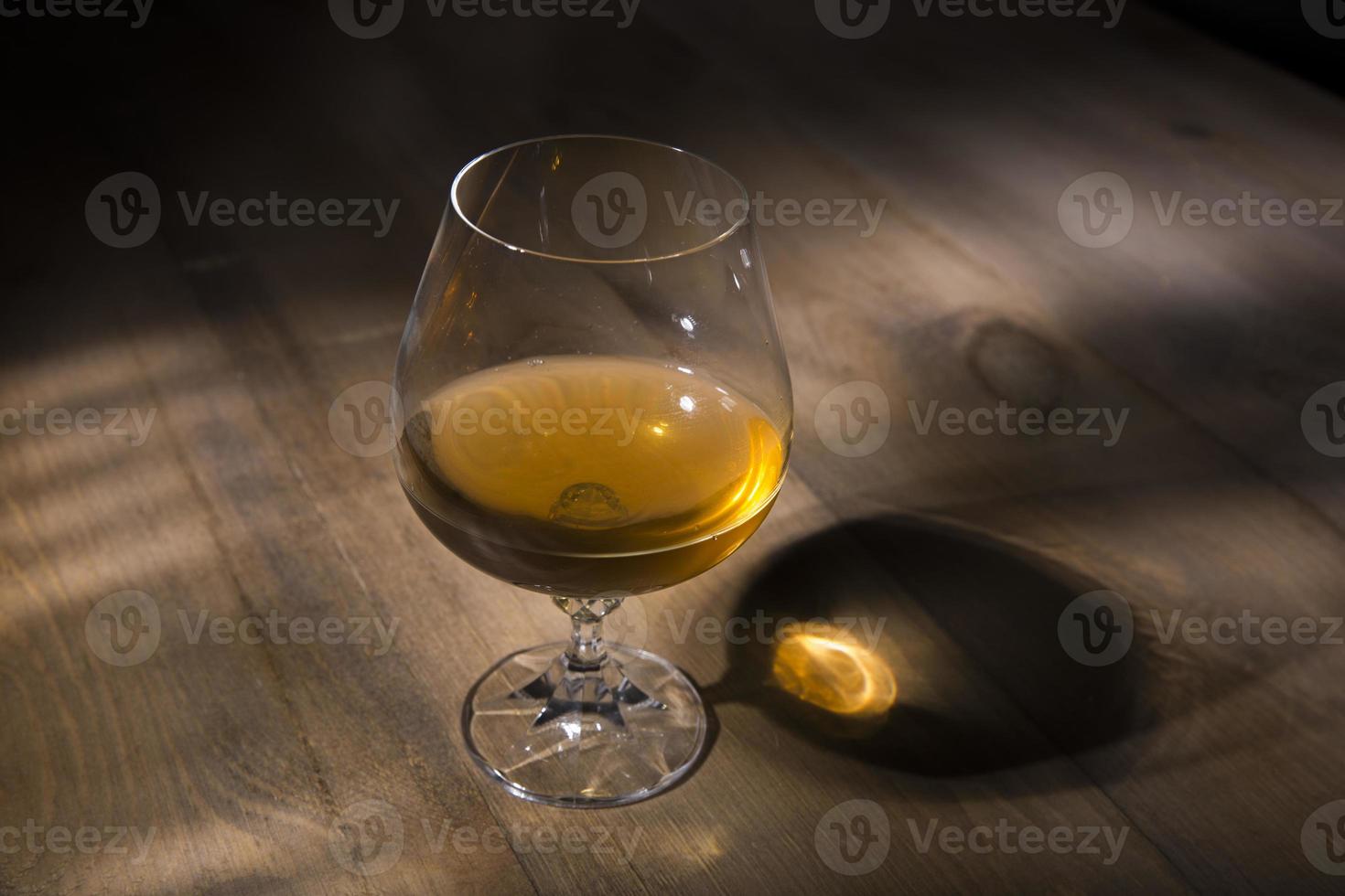 glas cognac of cognac op de houten tafel foto