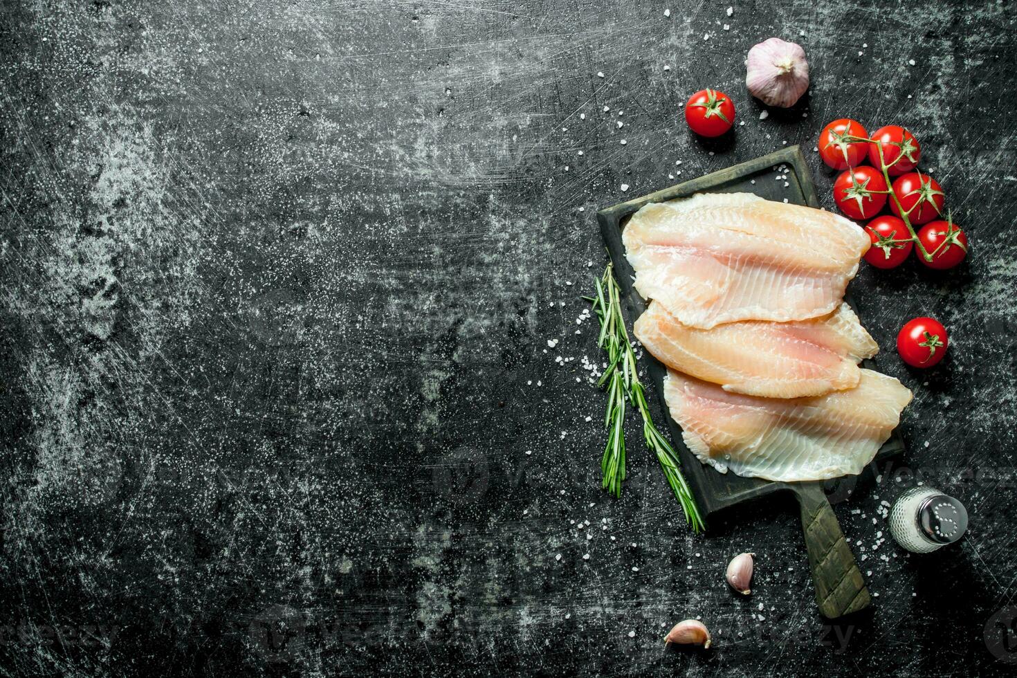 tilapia vis filet met tomaten Aan een tak, rozemarijn, knoflook en zout. foto