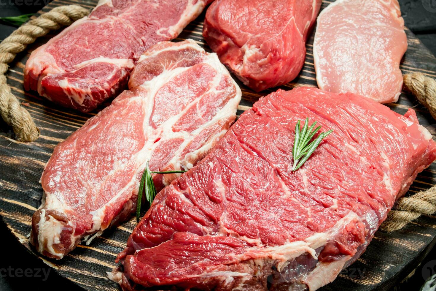rauw vlees. rundvlees en varkensvlees steaks Aan een houten dienblad. foto