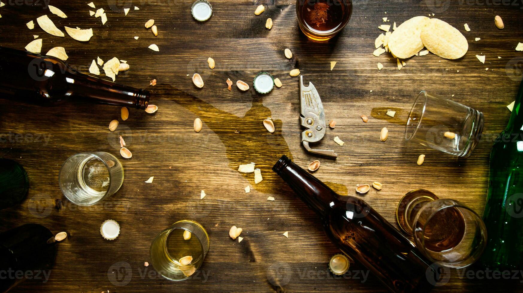 in de werkwijze van partij - gemorst bier, fles petten en overgebleven chips Aan de tafel. foto