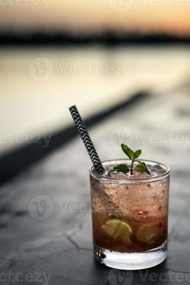 aardbei caipirinha gemengd cocktaildrankje in de buitenbar van vientiane laos aan de rivier bij zonsondergang foto