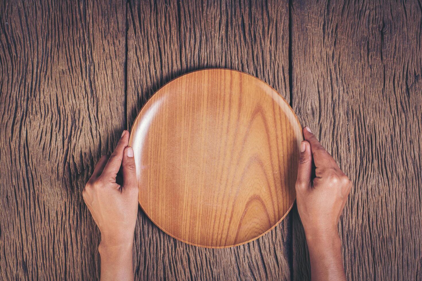 bovenaanzicht hand met plaat op hout achtergrond. foto