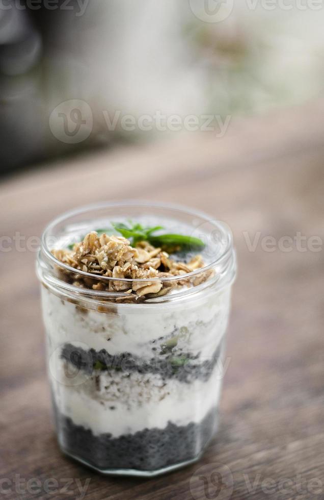 zelfgemaakte gezonde rustieke yoghurt en granola met basilicumzaden ontbijtsnackbeker foto