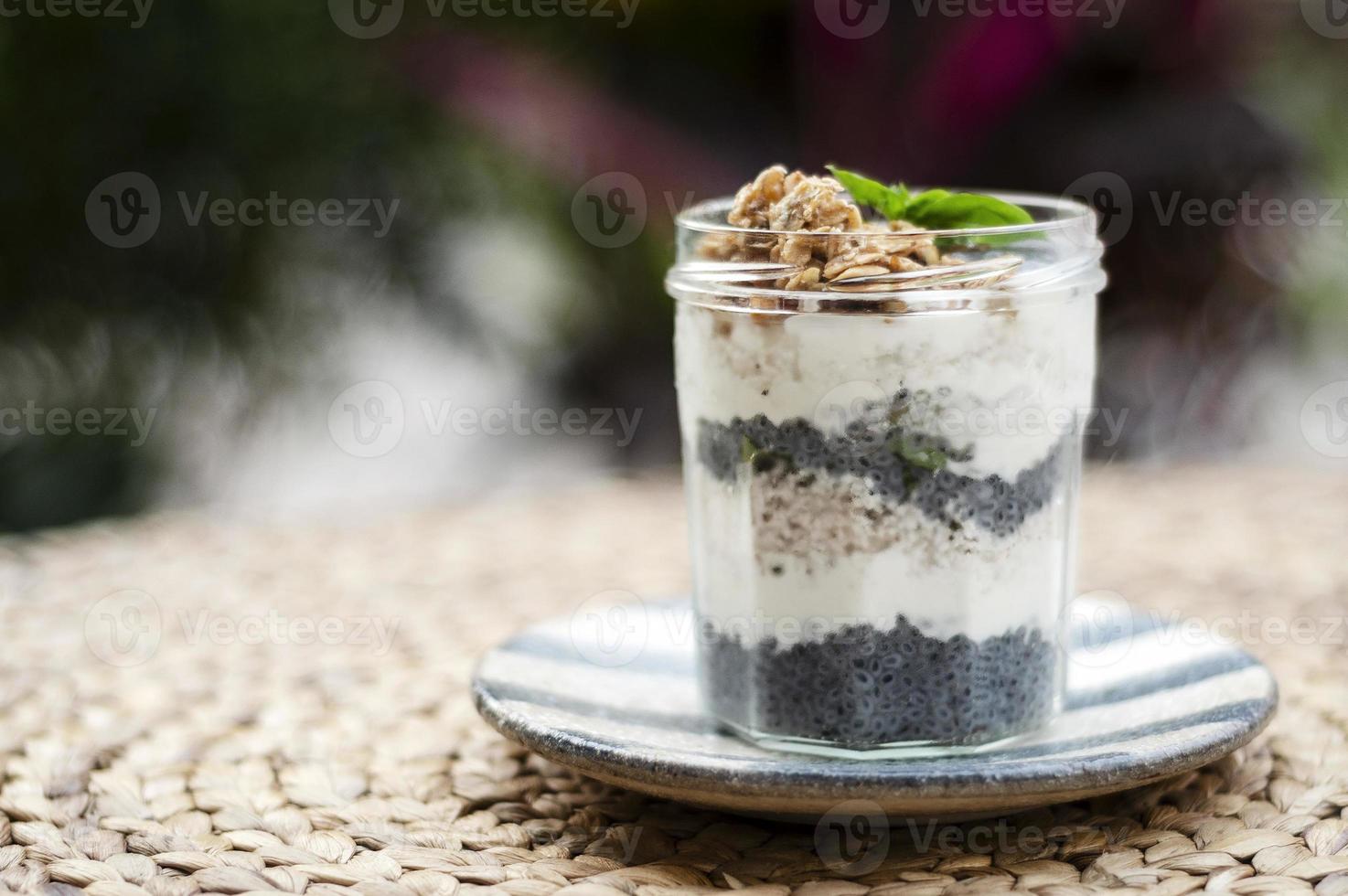 zelfgemaakte gezonde rustieke yoghurt en granola met basilicumzaden ontbijtsnackbeker foto