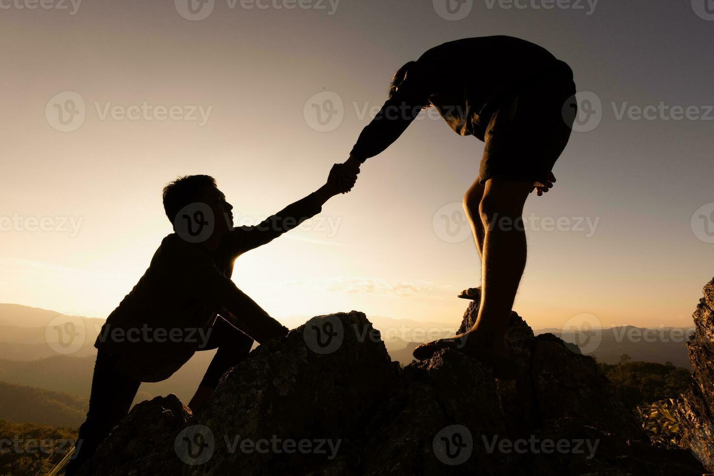 silhouetten van twee mensen beklimming Aan berg en helpen. helpen en bijstand concept. silhouet van samenspel Aan de bergen helpen hand, sport- opleiding. foto