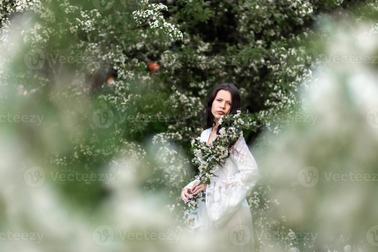 portret van jonge vrouw in het park in de bloeiende takken foto