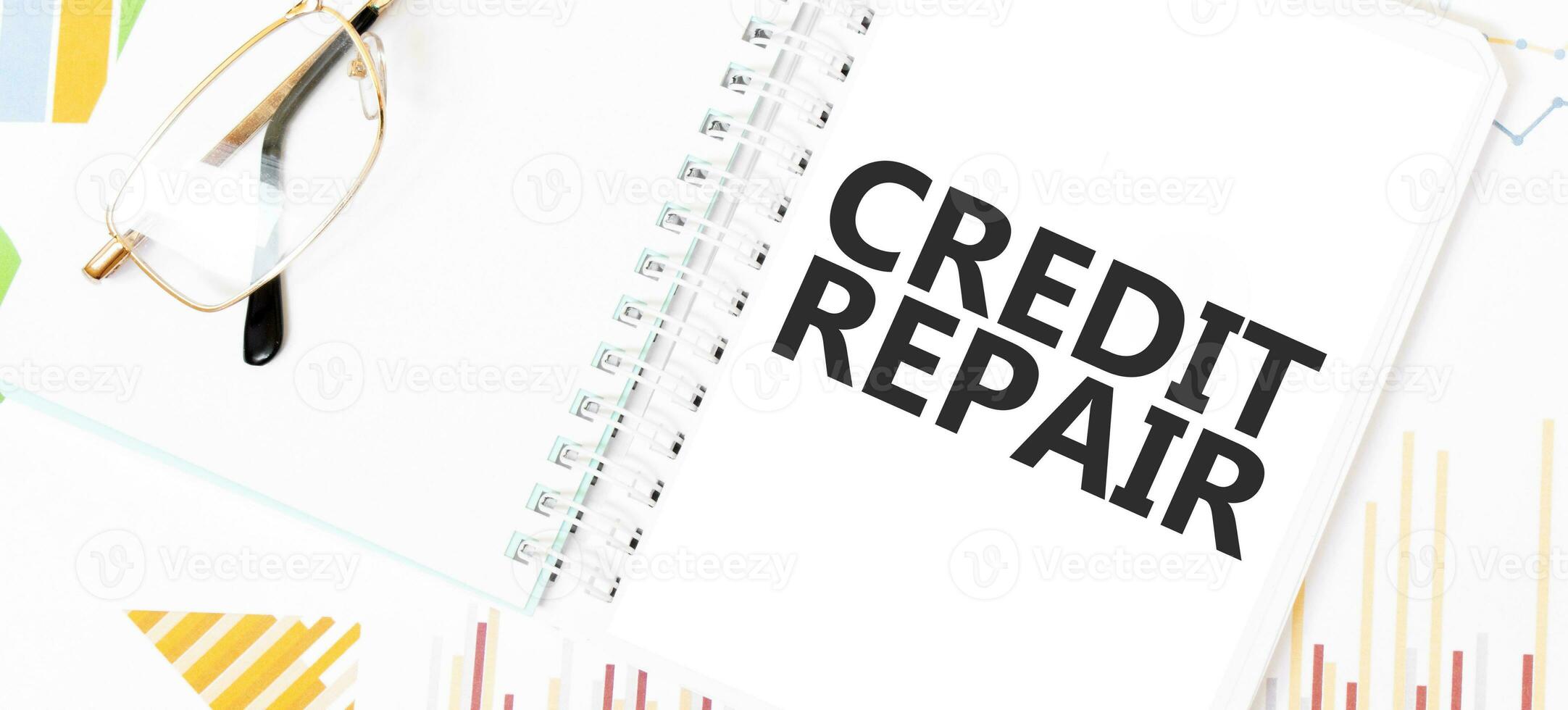 tekst credit reparatie Aan wit kladblok, bril, grafieken en diagrammen. foto